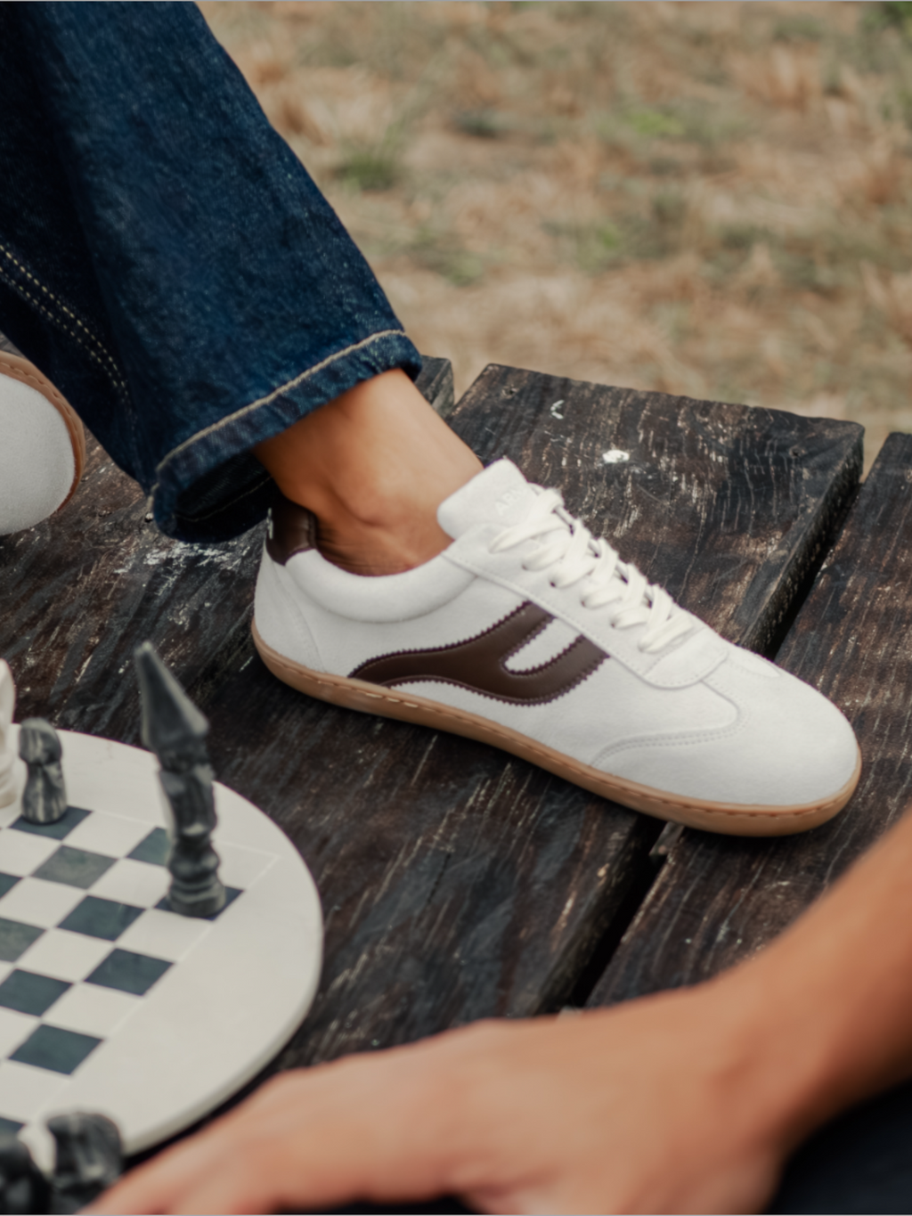 Zapatillas barefoot Atlantic Mist blancas sobre mesa de madera junto a tablero de ajedrez — ARNASA