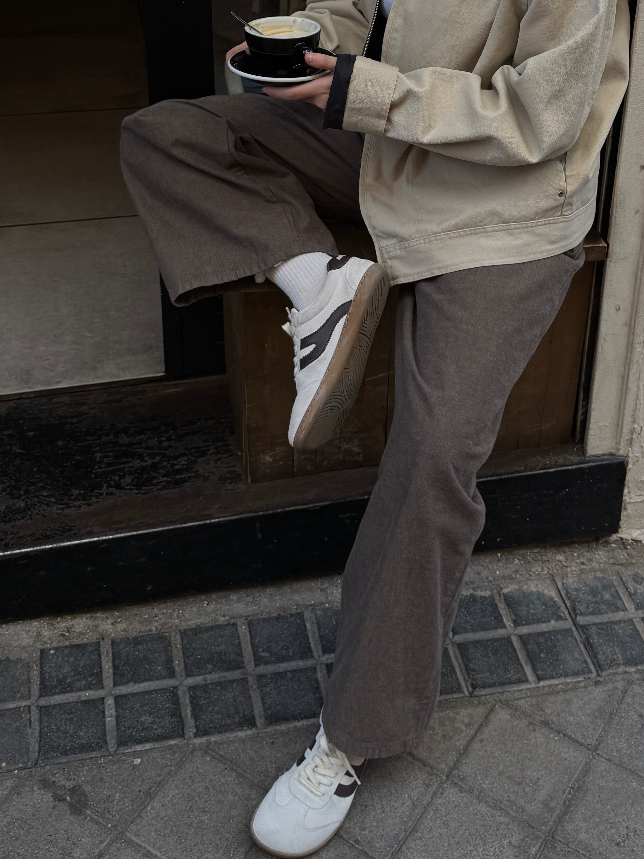 Persona con café en mano llevando zapatillas barefoot Atlantic Mist blanco niebla en ciudad — ARNASA