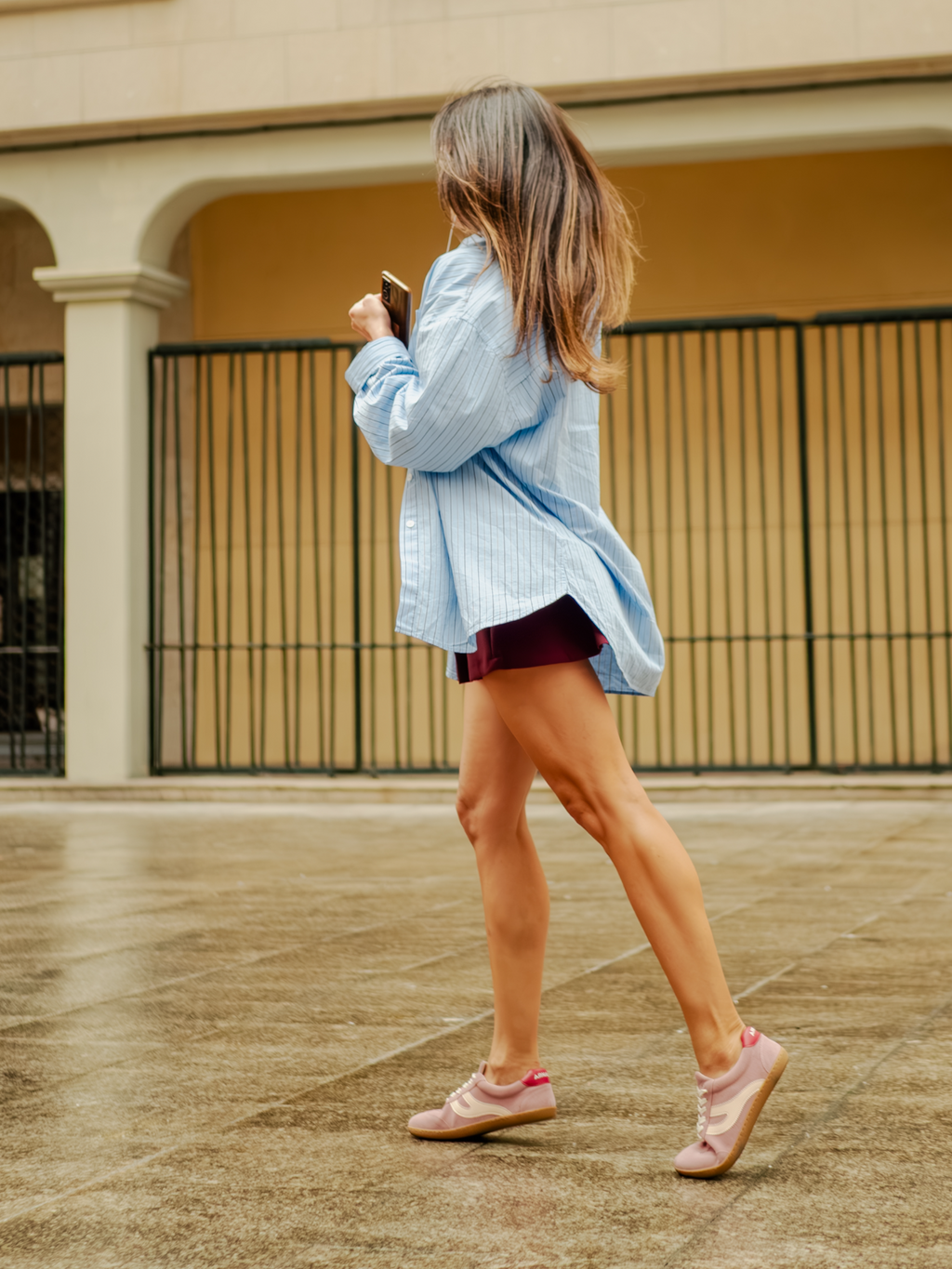 Mujer caminando con camisa azul y zapatillas barefoot Atlantic Bloom rosa empolvado en exterior — ARNASA