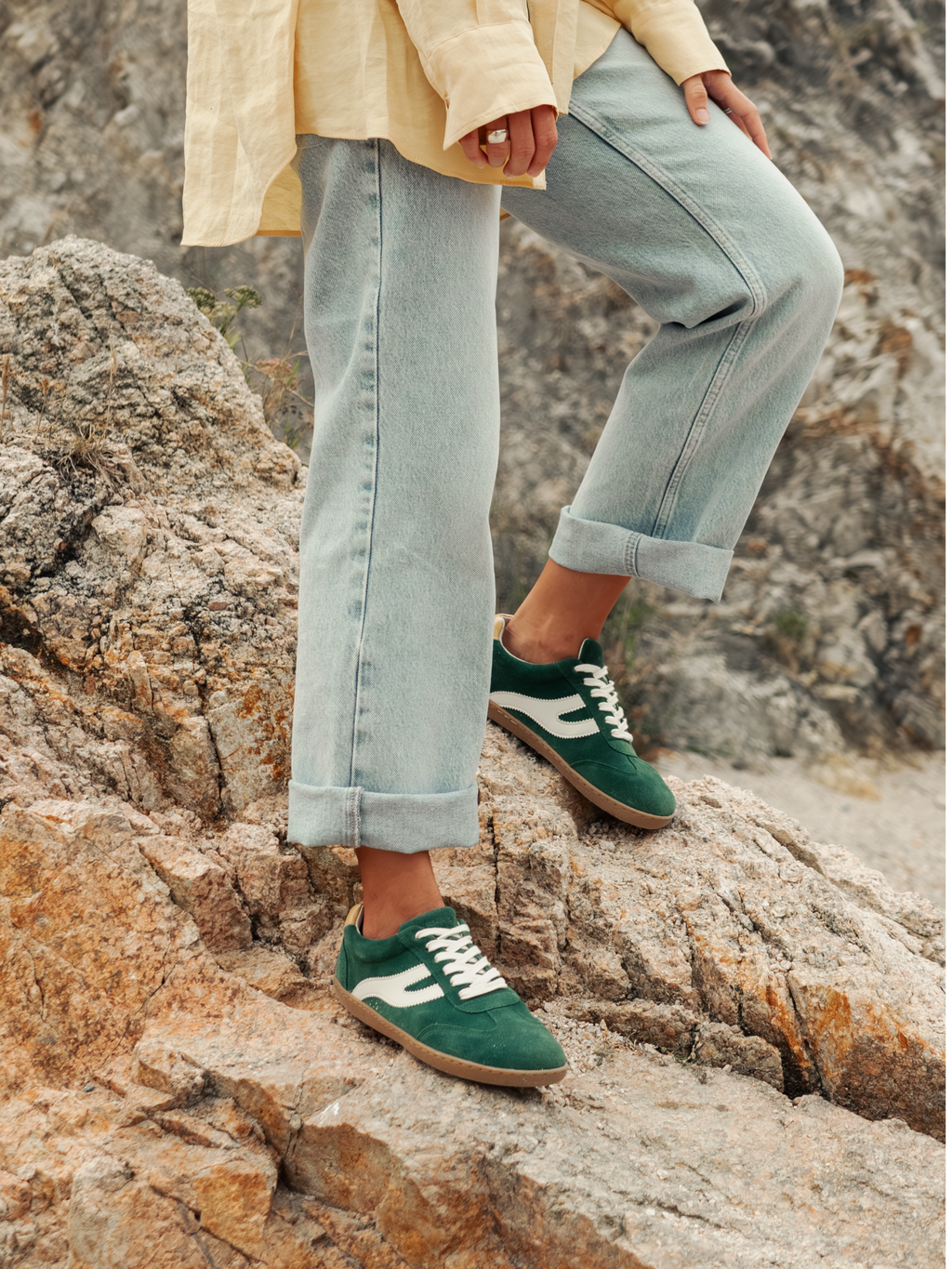 Persona con vaqueros llevando zapatillas barefoot Atlantic Forest verde bosque sobre rocas — ARNASA